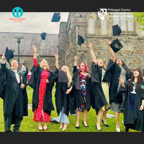 seven MA Voice Pedagogy students stand outside the University of Wales Trinity Saint David and throw their mortarboards in the air